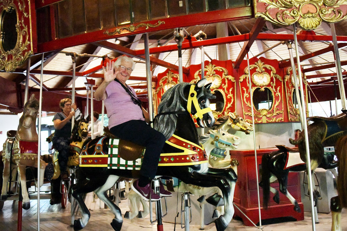 080 LaVerna Quiring with Glenda Anderson behind her at the Heritage Gardens carousel.jpg